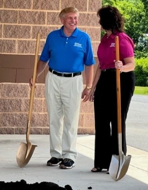 holding shovels at groundbreaking event